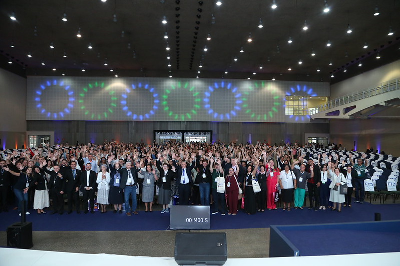Participantes de braços erguidos no auditório do Congresso 2025